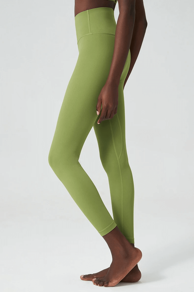 Woman wearing stylish ankle-length yoga leggings in green, perfect for versatile workouts like yoga, running, or gym sessions.